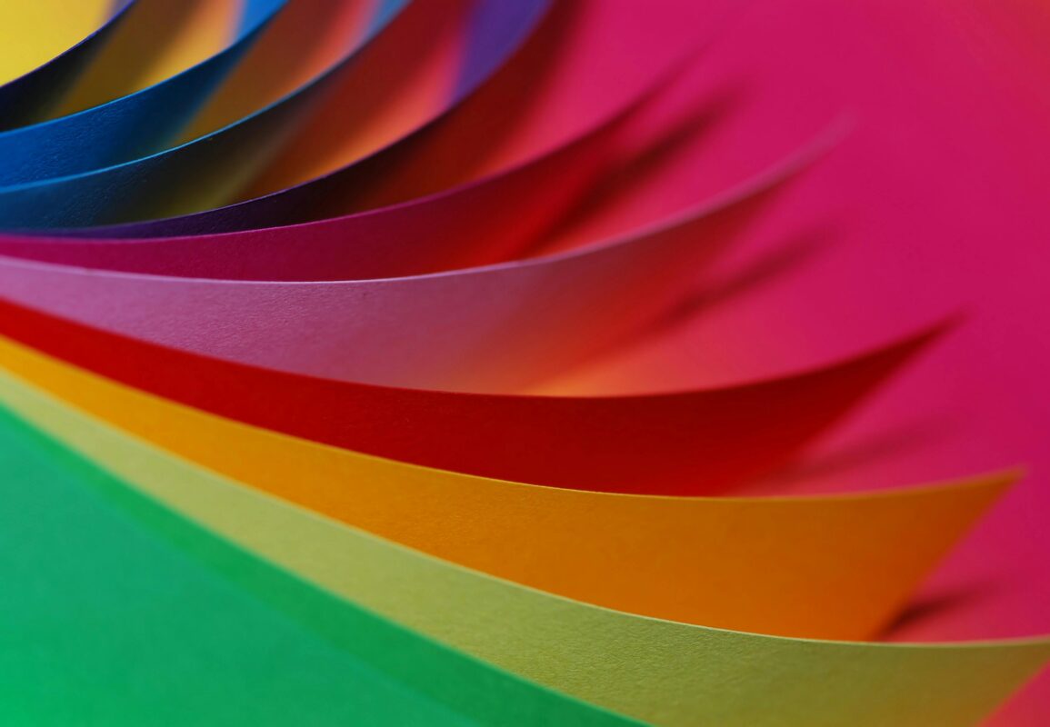 Vibrant layers of colorful paper arranged in a dynamic, abstract pattern.